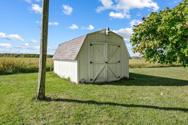 view of outdoor structure with a lawn and a rural view