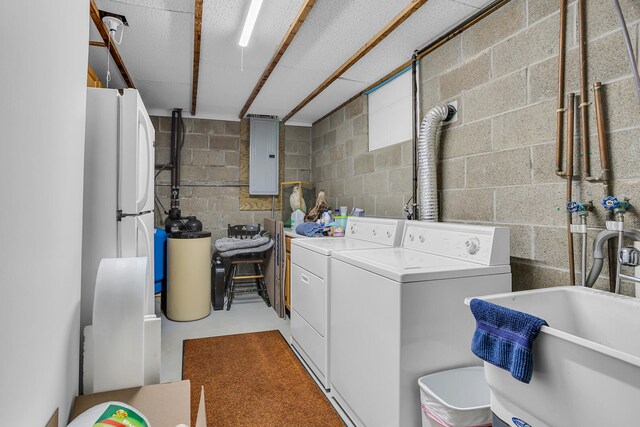 clothes washing area with electric panel, washing machine and clothes dryer, and sink