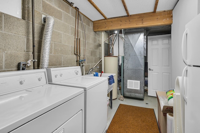 laundry room featuring gas water heater and washing machine and clothes dryer