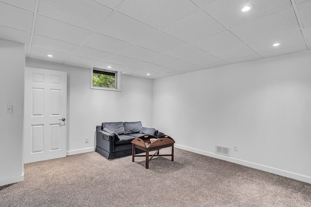 sitting room with carpet floors and a paneled ceiling