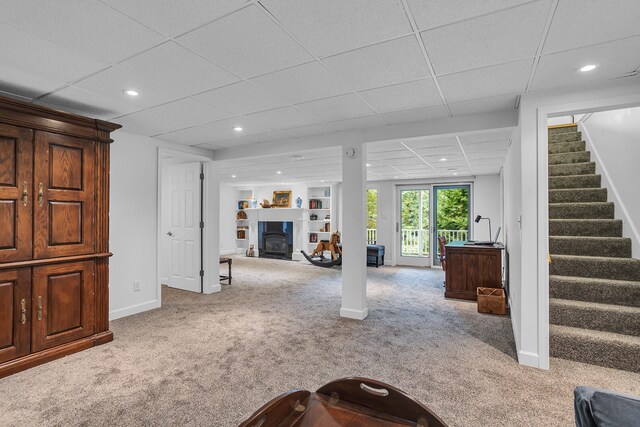 carpeted living room with a drop ceiling