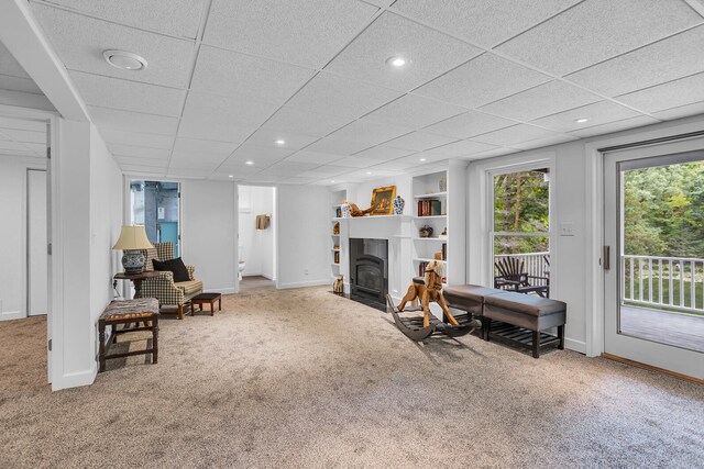 carpeted living room with a paneled ceiling