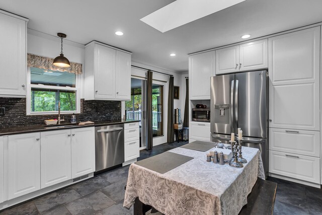 kitchen featuring sink, pendant lighting, stainless steel appliances, and plenty of natural light