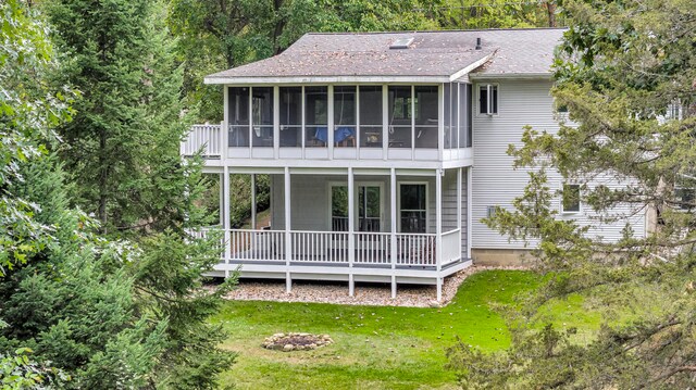 back of property featuring a sunroom and a lawn