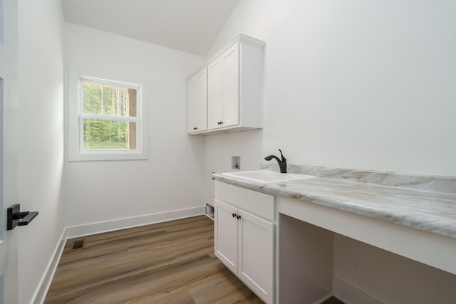 laundry room featuring cabinets, washer hookup, wood-type flooring, and sink