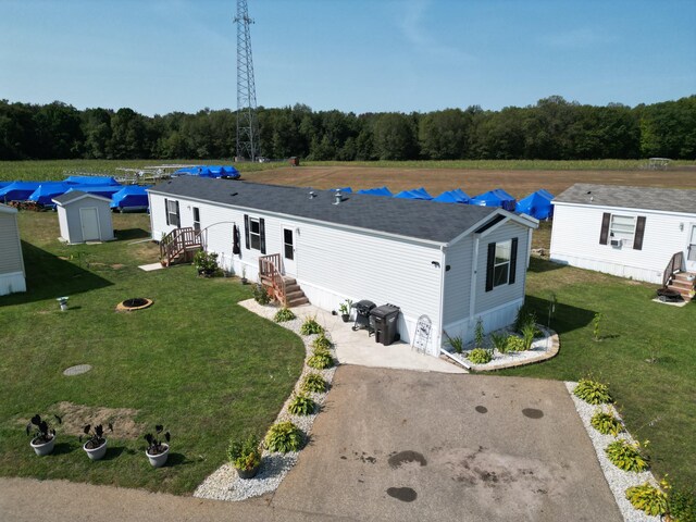 view of front facade with a storage unit and a front yard