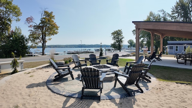 view of patio / terrace featuring a gazebo, a water view, and an outdoor fire pit