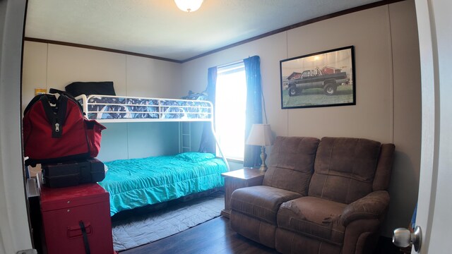 bedroom with dark hardwood / wood-style floors and crown molding