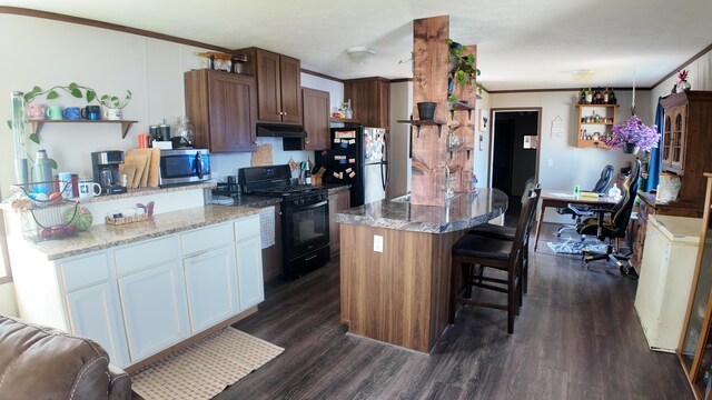 kitchen with white cabinetry, a kitchen island, dark hardwood / wood-style flooring, black appliances, and ornamental molding