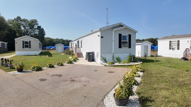 view of front of home with a front yard and an outbuilding