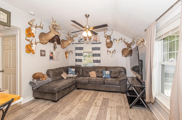 living room featuring a textured ceiling, vaulted ceiling, hardwood / wood-style floors, and ceiling fan