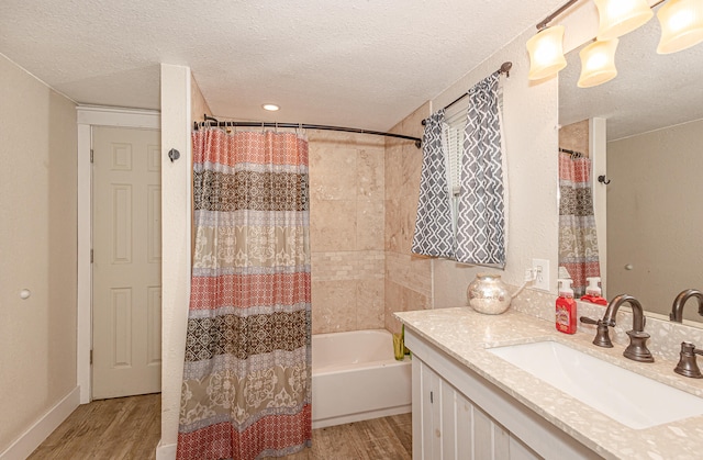 bathroom with shower / tub combo with curtain, a textured ceiling, hardwood / wood-style flooring, and vanity