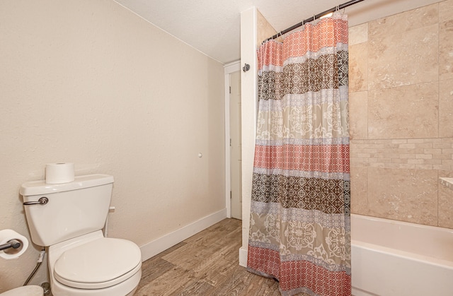 bathroom featuring a textured ceiling, hardwood / wood-style floors, toilet, and shower / tub combo with curtain