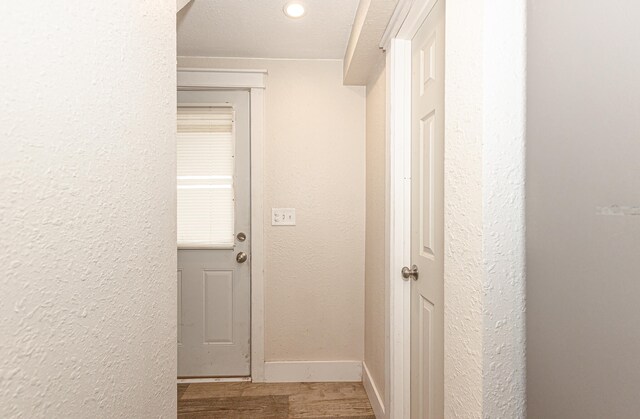 corridor featuring a textured ceiling and hardwood / wood-style floors