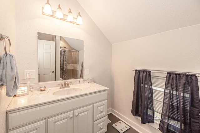 bathroom with vanity and lofted ceiling