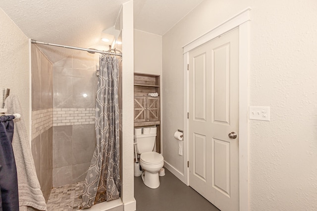 bathroom featuring a textured ceiling, toilet, and a shower with shower curtain