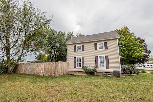 colonial house with central AC unit and a front yard