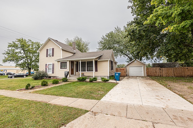 view of front of home featuring a front yard, an outbuilding, and a garage