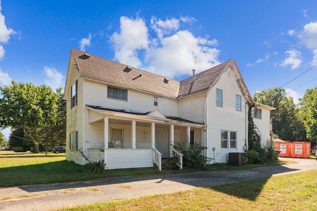 view of front of home featuring a front yard, a porch, and central AC unit