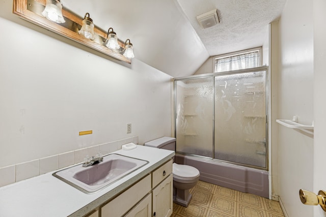 full bathroom featuring vanity, lofted ceiling, a textured ceiling, bath / shower combo with glass door, and toilet