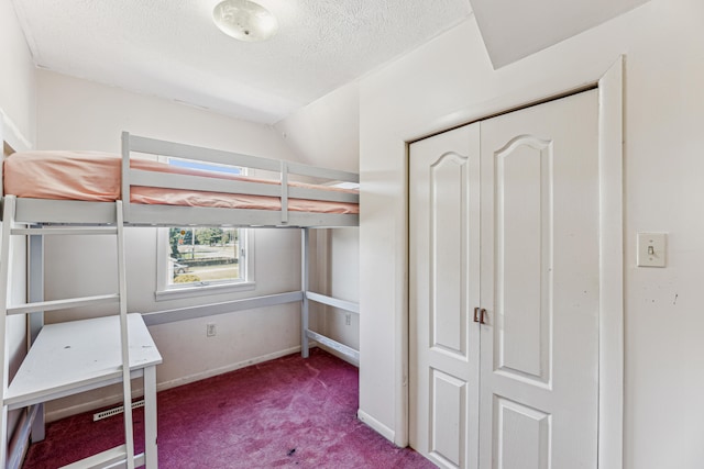 unfurnished bedroom featuring carpet floors, a textured ceiling, a closet, and lofted ceiling