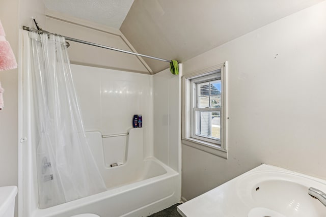 full bathroom featuring sink, shower / bath combo with shower curtain, toilet, and a textured ceiling