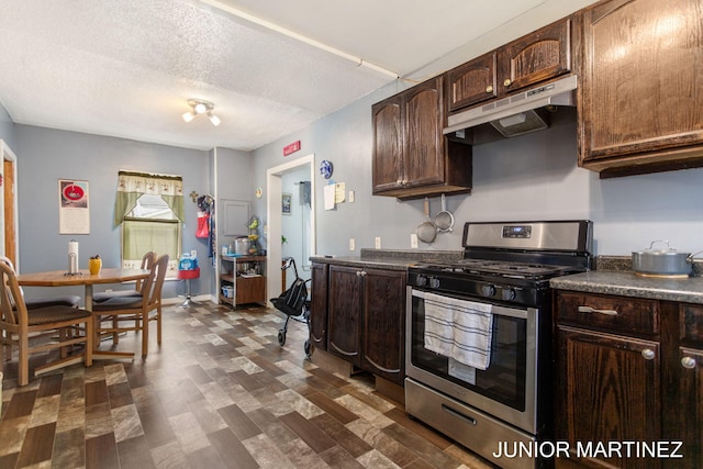 kitchen with dark brown cabinetry, gas range, and a textured ceiling