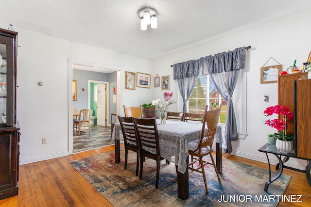 dining area featuring a textured ceiling and wood-type flooring