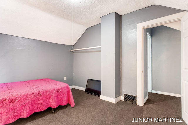 carpeted bedroom featuring vaulted ceiling and a textured ceiling