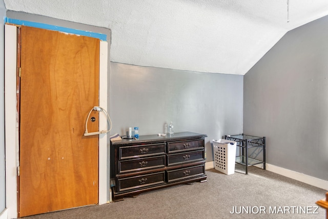 bedroom with light carpet, lofted ceiling, and a textured ceiling