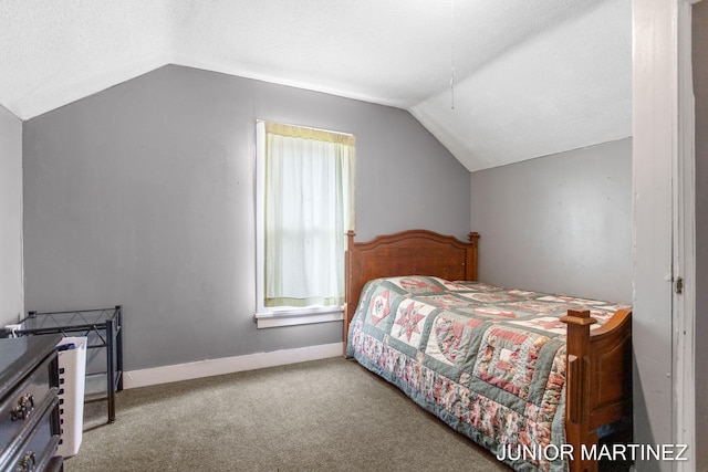 carpeted bedroom featuring a textured ceiling and vaulted ceiling