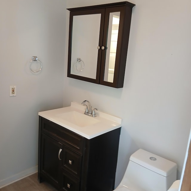 bathroom with hardwood / wood-style floors, vanity, and toilet