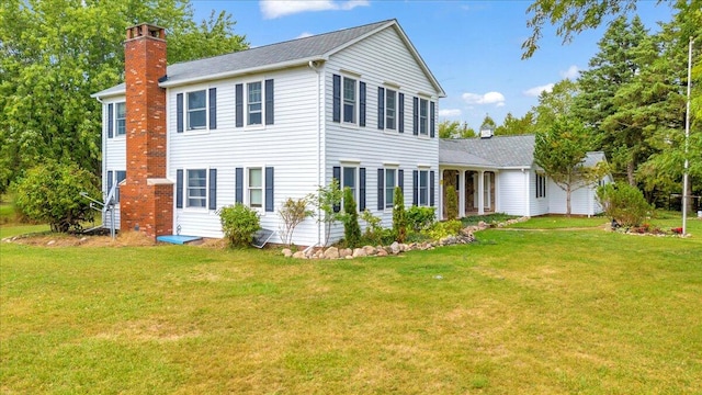 rear view of house featuring a lawn