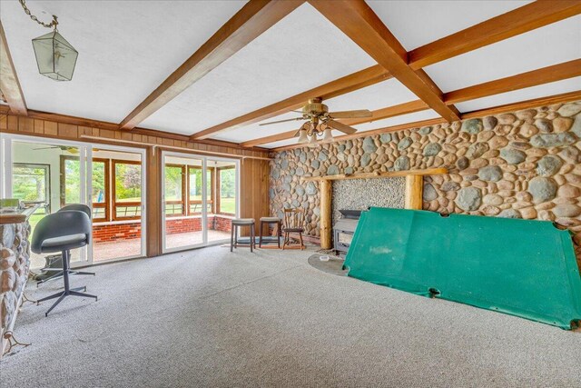 interior space with ceiling fan, beamed ceiling, and a fireplace