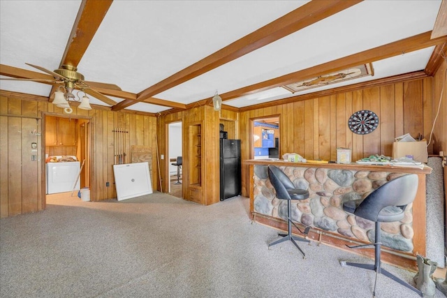 kitchen featuring wooden walls, beam ceiling, black refrigerator, and ceiling fan