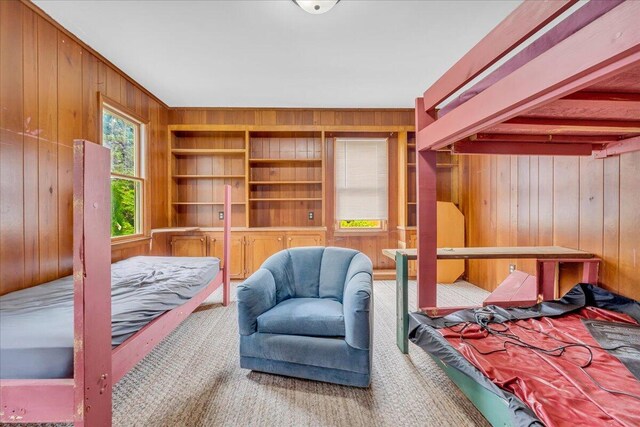 bedroom with carpet and wooden walls