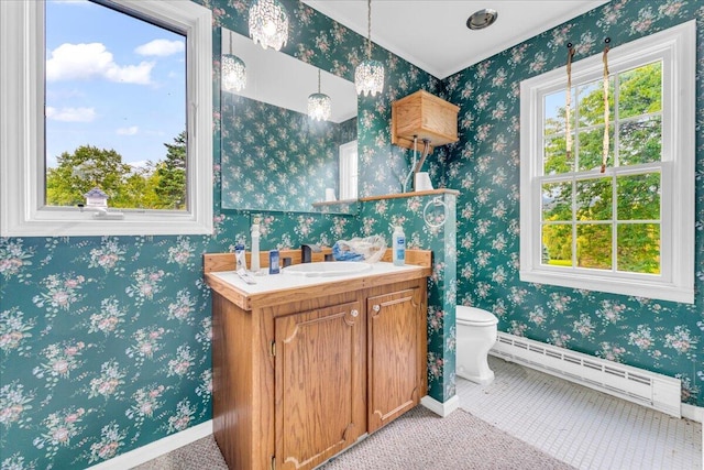 bathroom with a wealth of natural light, baseboard heating, vanity, and toilet