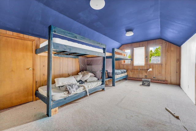 carpeted bedroom featuring wooden walls and vaulted ceiling