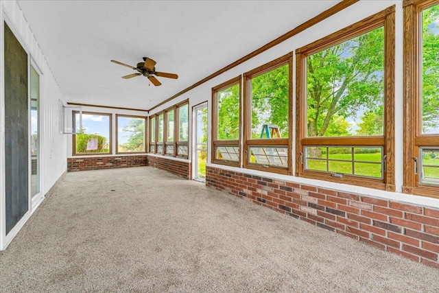 unfurnished sunroom featuring ceiling fan and a healthy amount of sunlight