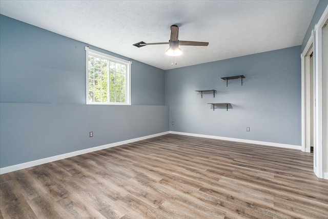 unfurnished room with ceiling fan, hardwood / wood-style flooring, and a textured ceiling