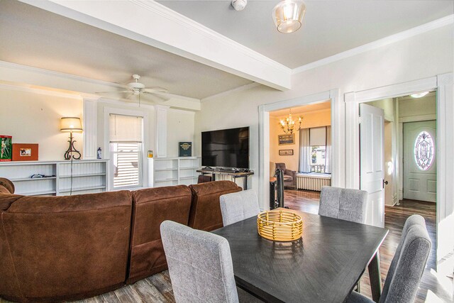 dining room with hardwood / wood-style flooring, ceiling fan with notable chandelier, crown molding, and radiator heating unit