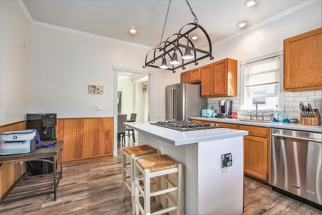 kitchen with appliances with stainless steel finishes, dark wood-type flooring, a kitchen breakfast bar, and a center island