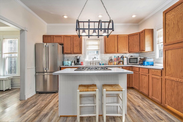 kitchen with hardwood / wood-style flooring, appliances with stainless steel finishes, and a kitchen island