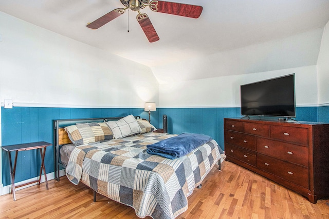 bedroom featuring light wood-type flooring, vaulted ceiling, and ceiling fan