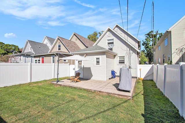 rear view of property featuring a patio and a lawn