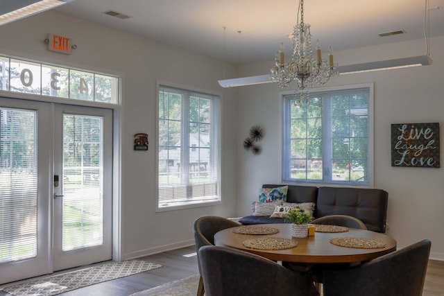 dining area featuring a notable chandelier, french doors, and hardwood / wood-style flooring