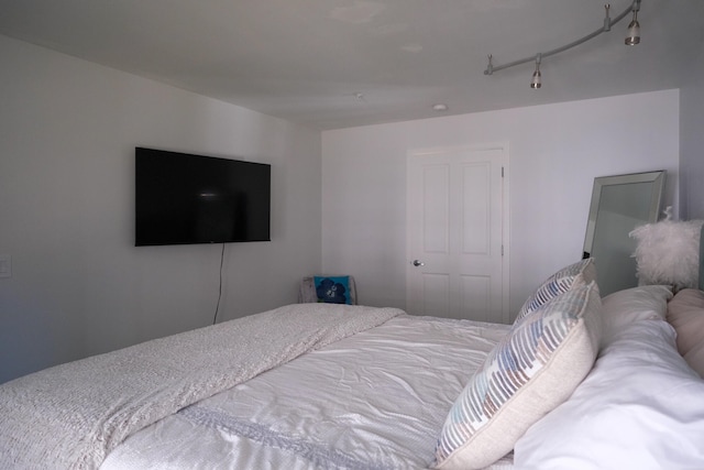 bedroom featuring track lighting