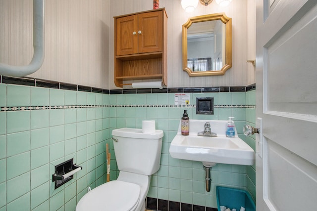 bathroom with sink, tile walls, and toilet