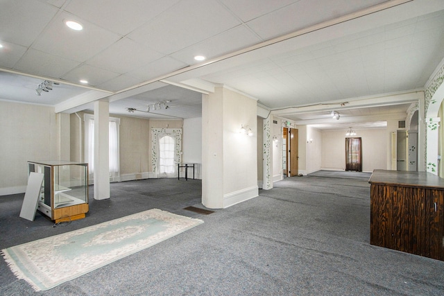 interior space featuring crown molding and dark colored carpet