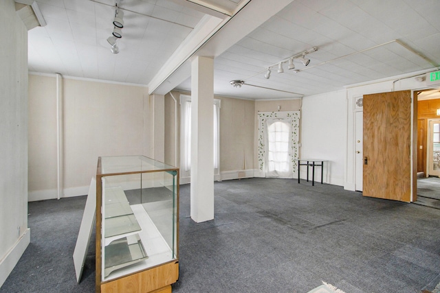 unfurnished room with dark colored carpet and rail lighting